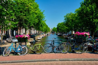 Amsterdam Kanalı 'nda bir köprü üzerinde tekneler ve bisikletlerle