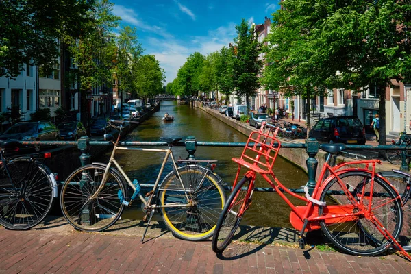 Canal de Ámsterdam con barcos y bicicletas en un puente —  Fotos de Stock