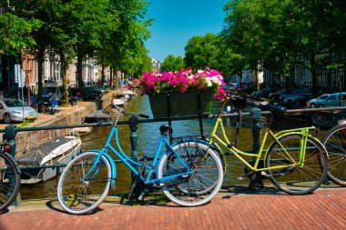 Amsterdam Kanalı 'nda bir köprü üzerinde tekneler ve bisikletlerle