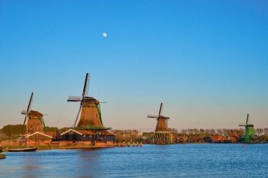 Hollanda Zaanse Schans 'daki yel değirmenleri gün batımında alacakaranlıkta. Hollanda