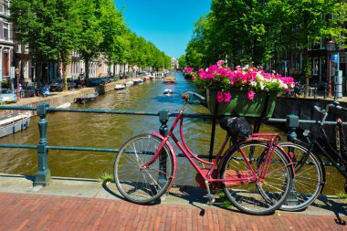 Amsterdam Kanalı 'nda bir köprü üzerinde tekneler ve bisikletlerle