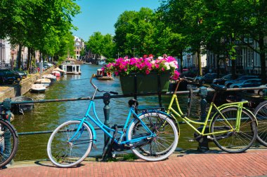 Amsterdam Kanalı 'nda bir köprü üzerinde tekneler ve bisikletlerle