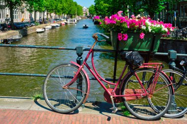 Amsterdam Kanalı 'nda bir köprü üzerinde tekneler ve bisikletlerle