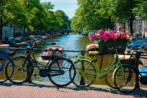 Canal de Ámsterdam con barcos y bicicletas en un puente —  Fotos de Stock