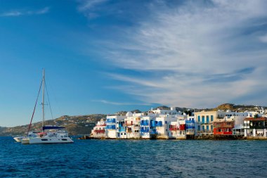 Yunanistan 'ın Mykonos kentinde günbatımı, limanda yolcu gemisi ve yatlarla