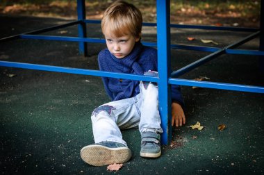 Çocuk masa altında oturuyor