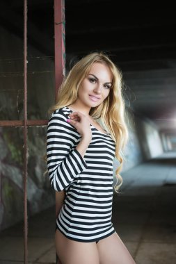 Seksi sarışın kadın çizgili bluz demir çit poz 
