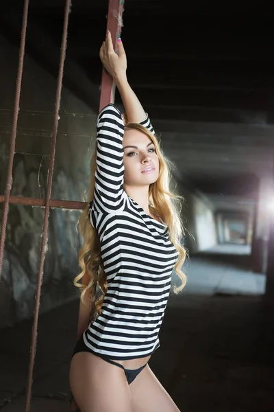 Сексуальная Молодая Блондинка Полосатой Блузке Позирует Возле Железного Забора — стоковое фото