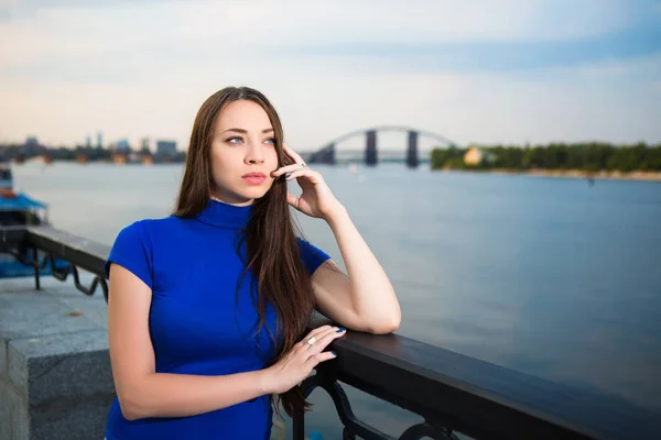 Portrait of nice young woman posing near river