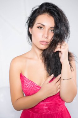 Pembe elbise beyaz duvar önünde poz seksi genç kadın portresi