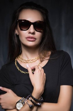 Lüks mücevher ve güneş gözlüğü gri duvar önünde glamourous genç esmer portresi