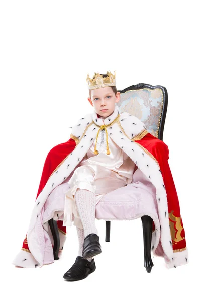 可爱的男孩穿着国王的服装和摆在宝座上 在白色上隔离 — 图库照片