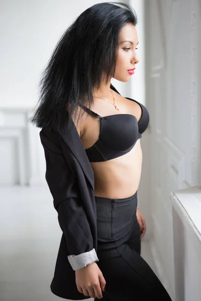 年轻性感的黑发在黑色胸罩摆姿势附近的窗口 — 图库照片