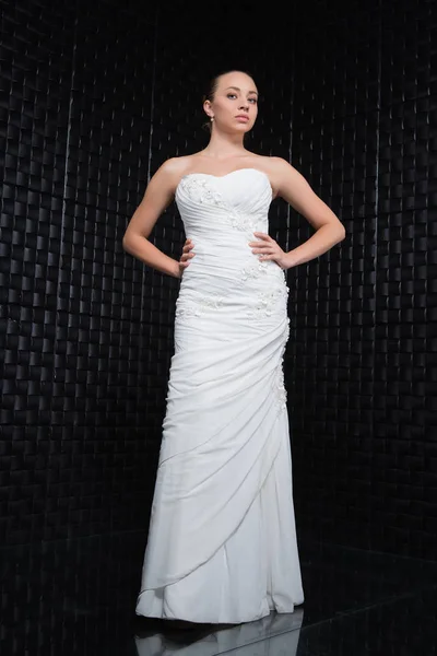 Piękna Młoda Kobieta Sobie Suknię Ślubną Białą Stojąc Rękami Okrakiem — Zdjęcie stockowe