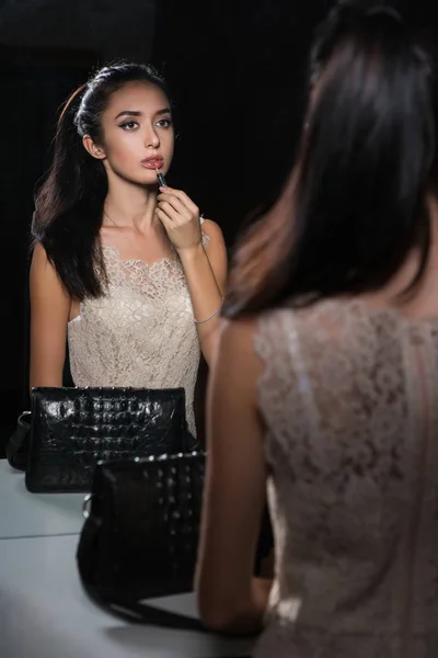 化粧をしていると 鏡を見てかなり若いブルネットの女性の反射 — ストック写真