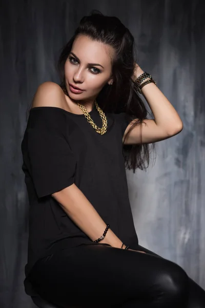 Ung Kvinna Poserar Trendiga Kläder Och Smycken Framför Grå Vägg — Stockfoto