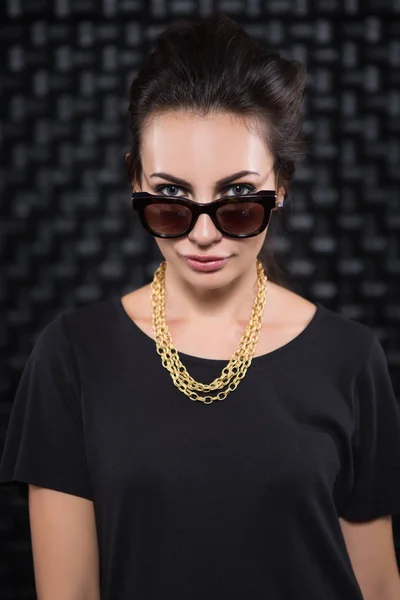 Mujer Bonita Posando Gafas Sol Cadena Dorada Delante Pared Oscura — Foto de Stock