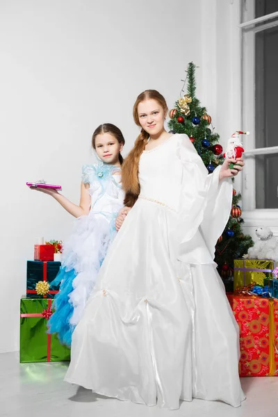 Hermanas Vestidos Festivos Posando Cerca Del Árbol Navidad Estudio —  Fotos de Stock