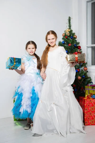 Hermanas Vestidos Festivos Posando Cerca Del Árbol Navidad Estudio —  Fotos de Stock