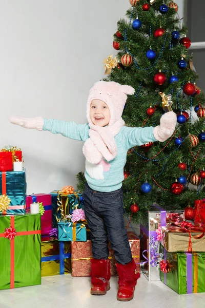 Glückliches Kleines Mädchen Steht Neben Weihnachtsbaum Und Verpackten Geschenken — Stockfoto