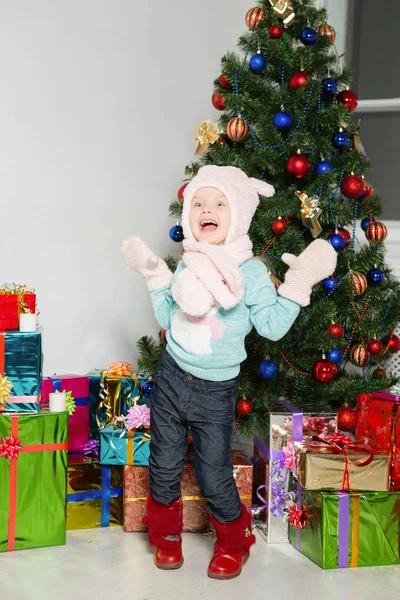 幸せの小さな女の子が立っている付近のクリスマス ツリーとプレゼントをラップ — ストック写真