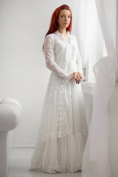 エレガントな白いドレスを着た赤い髪の若い女性 — ストック写真