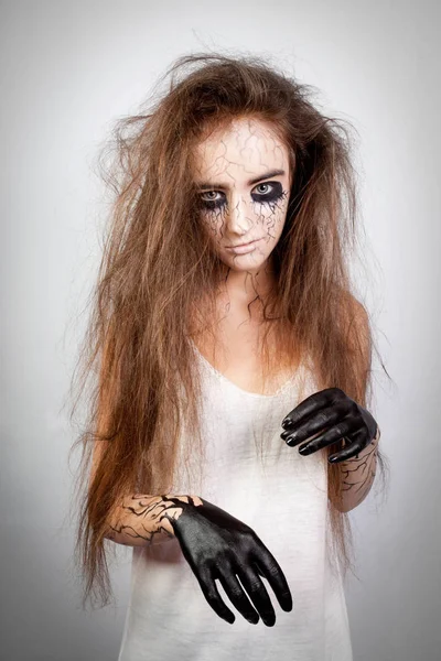 portrait of a crazy girl with disheveled hair, black eyes and veins. concept of halloween and day of the dead.