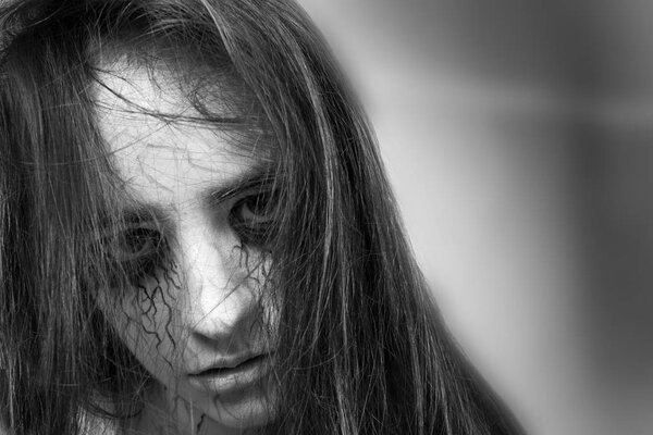 Хэллоуин. Портрет грустной девушки зомби с черными венами на лице. концепция Хэллоуина и дня мертвых
.