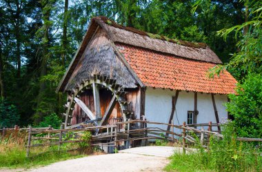 Watermill ve kırmızı kiremitli çatı ile eski ahşap çerçeveli ev