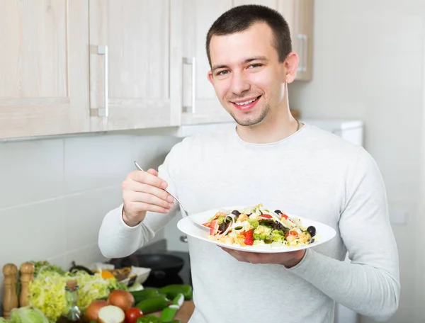 Ο άνθρωπος τρώει σαλάτα λαχανικών σε kitche — Φωτογραφία Αρχείου