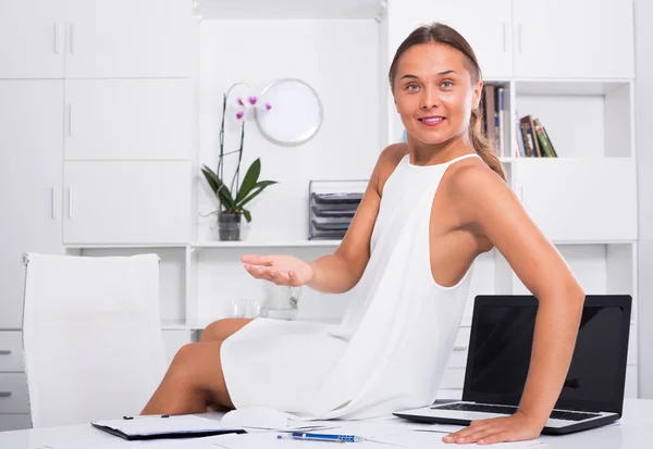 Giovane donna sorridente che si rilassa sulla scrivania con documenti — Foto Stock