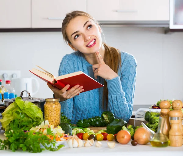 Mädchen im Pullover lernt neues Rezept aus Kochbuch — Stockfoto