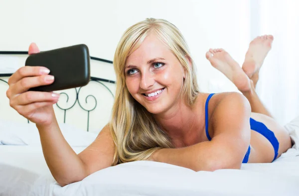 Sensual blondie in sexy underwear making selfie — Stock Photo, Image