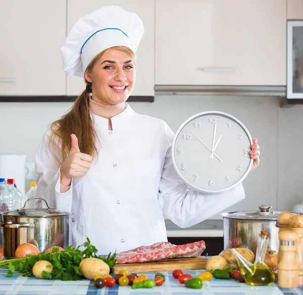 Профессиональный повар со свиной грудью и часами на кухне — стоковое фото