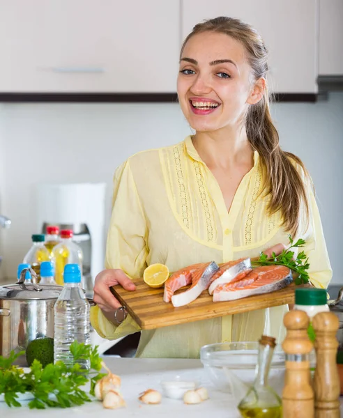 Girl in yellow blouse with fresh salmon fillet — Stock Photo, Image