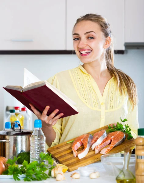 Aantrekkelijk meisje met lang haar controleren recepten — Stockfoto