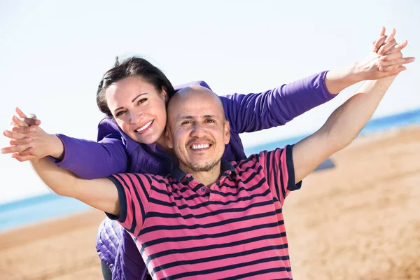 Couple gladly hugging each other and enjoying the beach — Stock Photo, Image