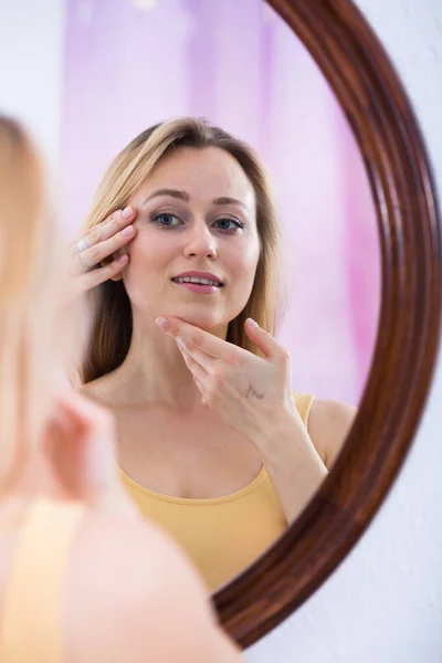 Woman looking at mirror — Stock Photo, Image