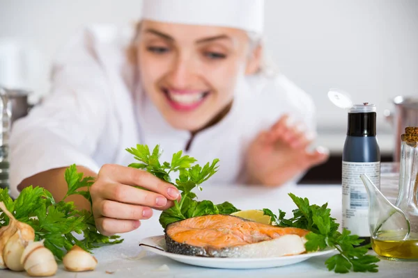 Young cook with prepared salmon in professional kitchen — Stock Photo, Image