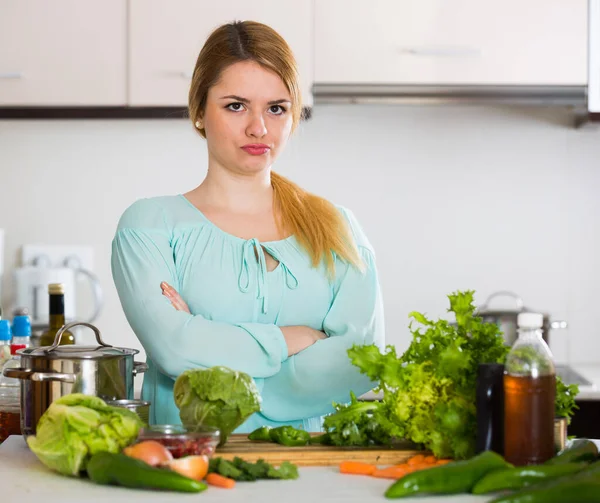 Jovem dona de casa cansada de cozinhar legumes na cozinha doméstica — Fotografia de Stock