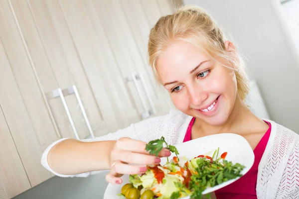 Девушка на кухне готовит салат — стоковое фото