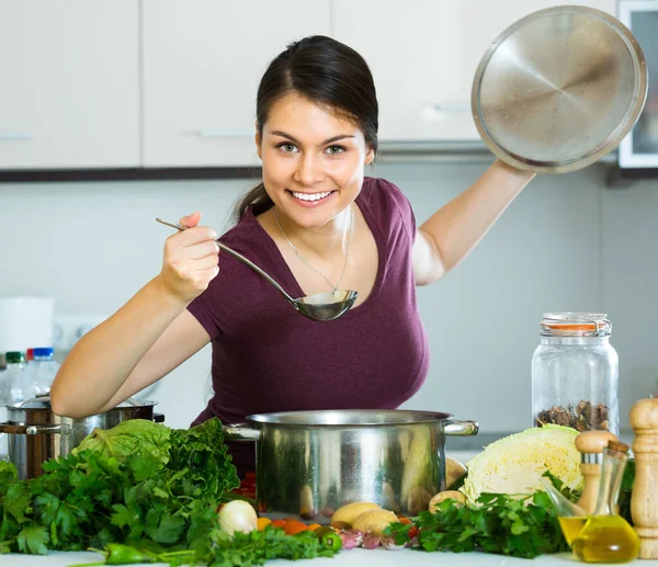 Mujer con verduras en la mesa de la cocina — Foto de Stock
