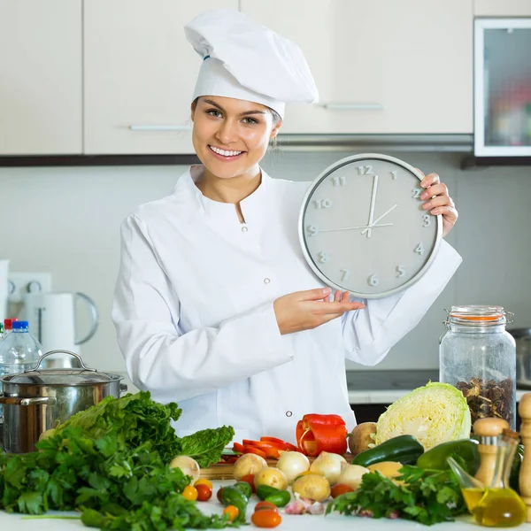 Donna con orologio in cucina — Foto Stock