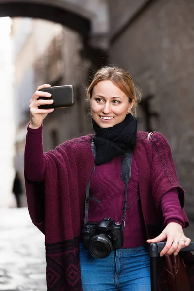 Menina tirando foto com seu telefone na cidade — Fotografia de Stock