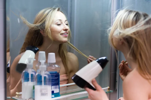 Дівчина сушить волосся у ванній — стокове фото