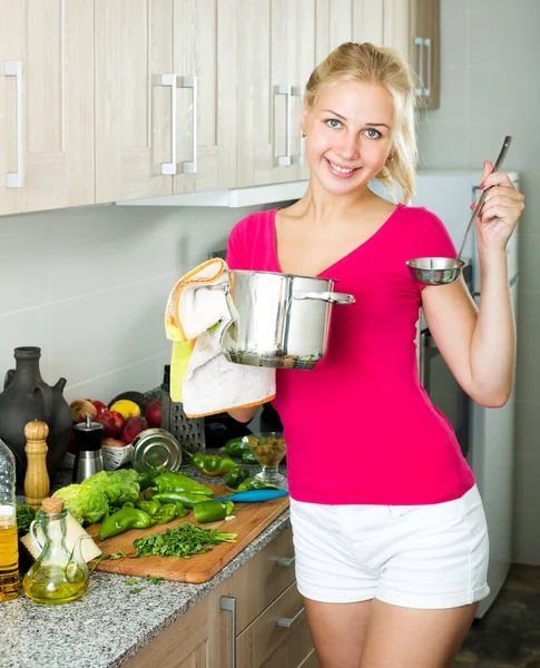 Meisje bereidt soep in kookpot — Stockfoto
