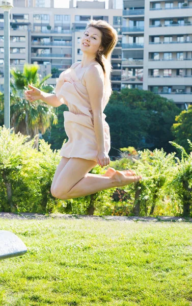 Yetişkin Bir Kadın Ince Elbisesiyle Neşeyle Parkta Zıplıyor — Stok fotoğraf