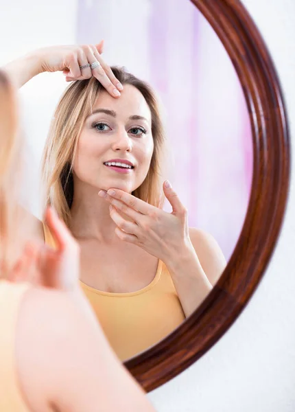 Vrolijke Glimlachende Vrouw Die Naar Haar Gezicht Kijkt Bij Spiegel — Stockfoto