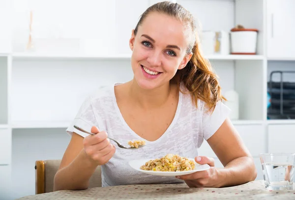 栗色の髪をした笑顔の女の子が粥を食べる — ストック写真