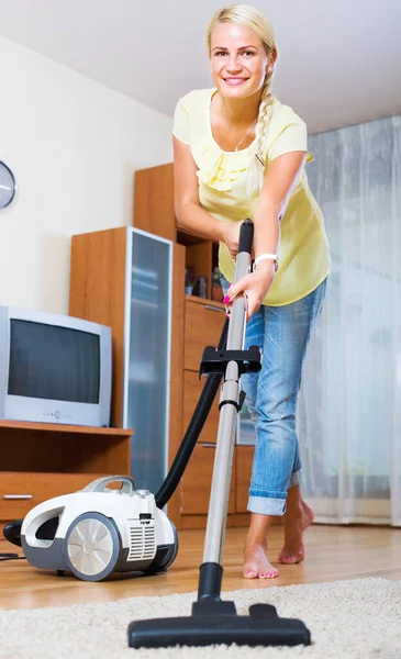 部屋で定期的に清掃中に掃除機を使用して若い女性 — ストック写真